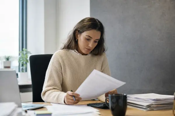 Business owner at her desk comparing finance paperwork